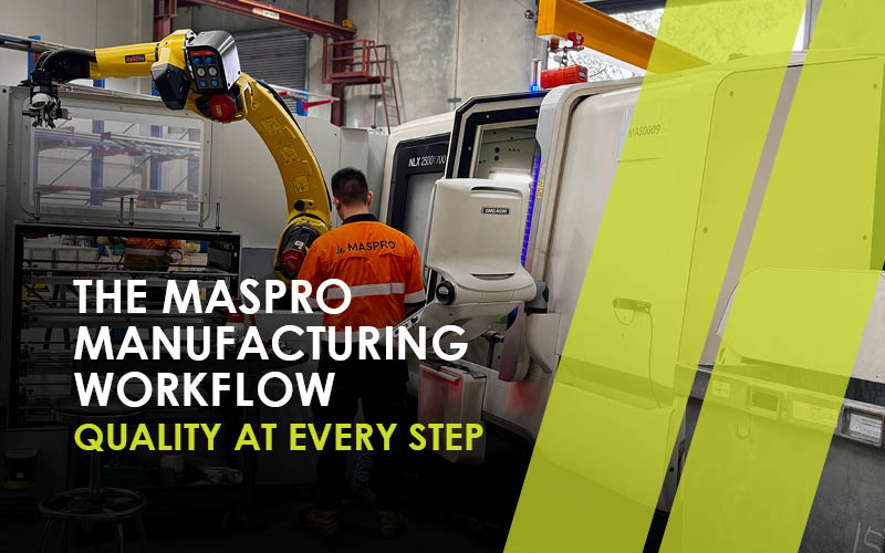 A MASPRO technician operates advanced CNC machinery alongside a robotic arm in a clean and organized manufacturing facility.